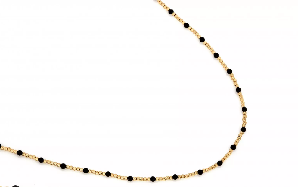 Zlatý náhrdelník zo 14-karátového žltého zlata zdobený čiernymi onyxmi. Elegantný kontrastný dizajn, ktorý spája klasiku a moderný štýl.