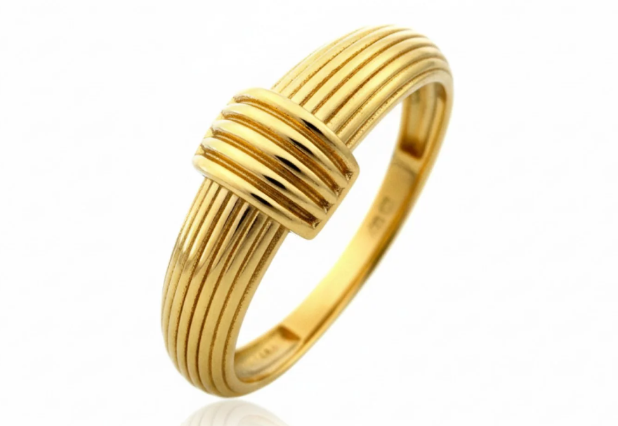 Výrazný zlatý prsteň s oválnou dominantou a dekoratívnymi detailmi.