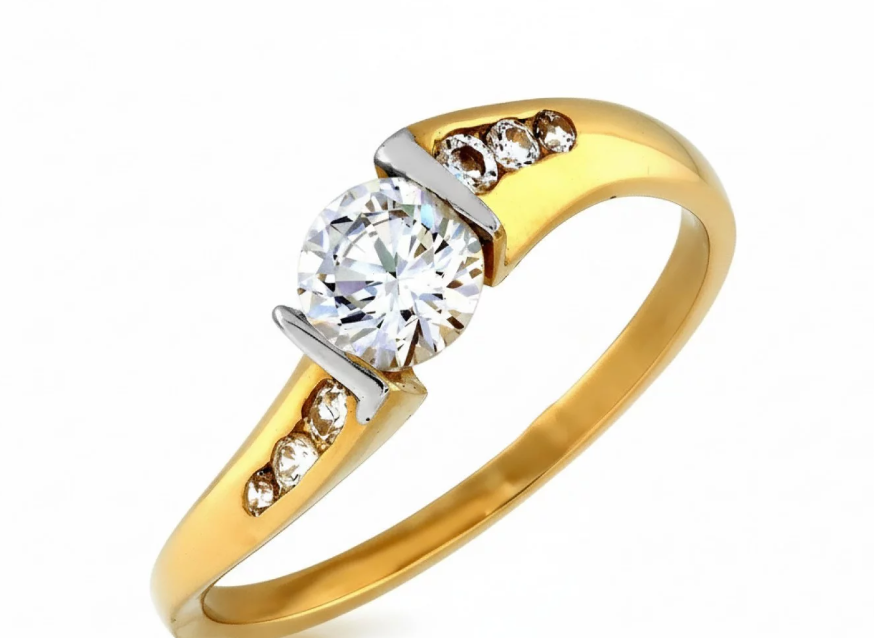 Elegantný zásnubný prsteň zo žltého zlata s výrazným centrálnym zirkónom a jemnými bočnými zirkónmi, ktorý rozžiari každý výnimočný okamih.