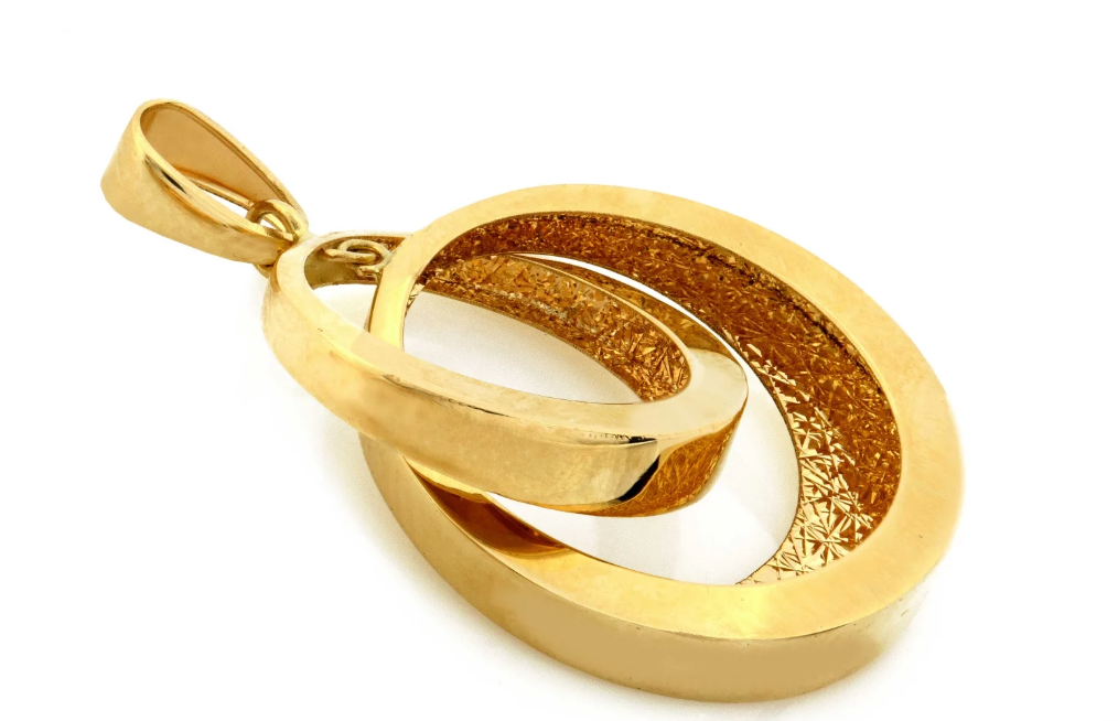 Zlatý prívesok Eterna Duo s prepleteným kruhovým dizajnom symbolizuje spojenie, eleganciu a nadčasový luxus. Výrazný šperk, ktorý okamžite upúta pozornosť.